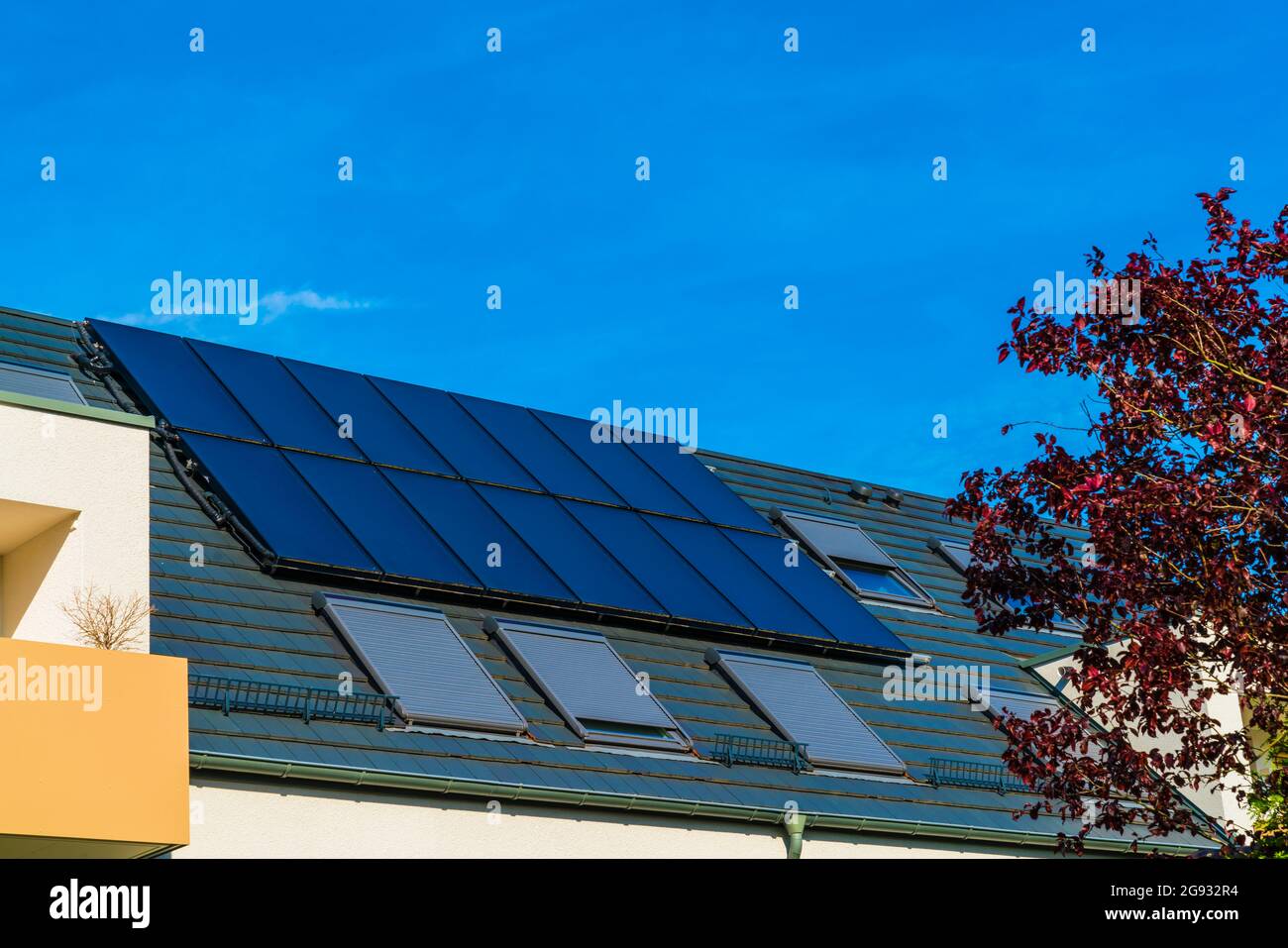 Solar energy generated on roof of a new house by many solar panels with the power of the sun Stock Photo