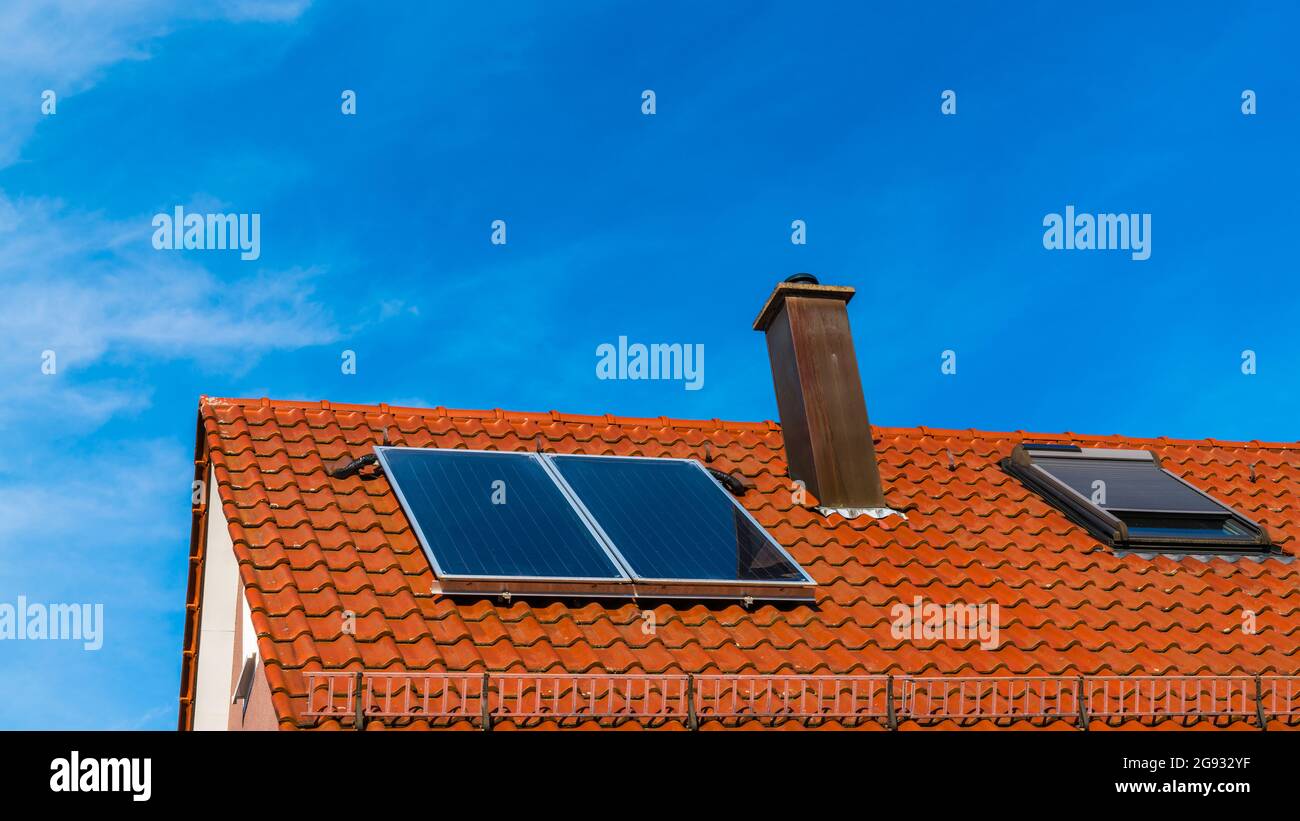 Solar panels on the red roof of a house generating clean energy for ...