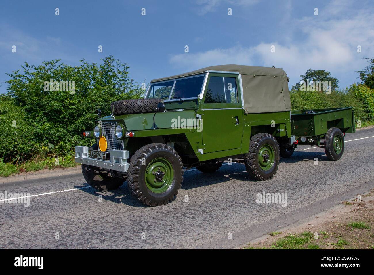 1968 60s green pristine Series IIA British Land Rover towing trailer, 2286 cc petrol LCV en-route to Capesthorne Hall classic July car show, Cheshire, UK Stock Photo