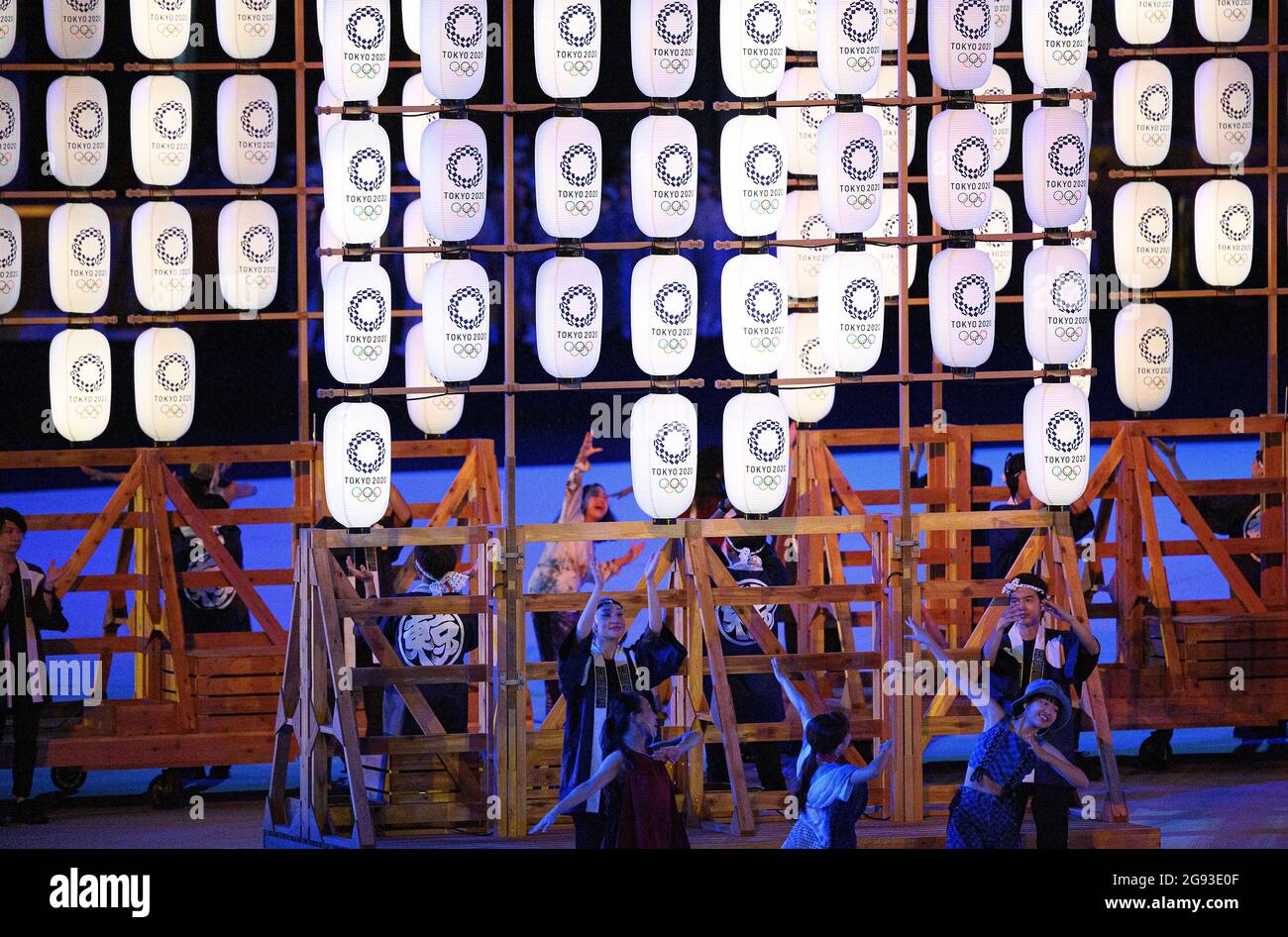 Choreography with lanterns on wooden frames, behind them dancers ...