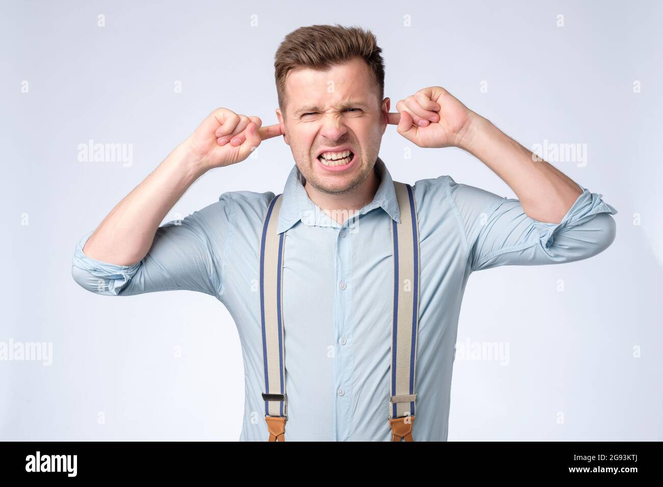 Caucasian young man with fingers in ear with not listening expression Stock Photo