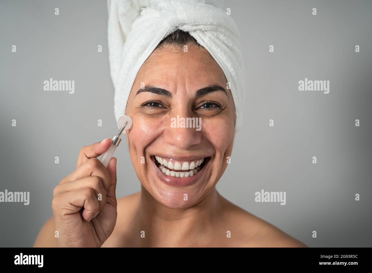 Happy Latin mature woman having skin care spa day - People wellness lifestyle concept Stock