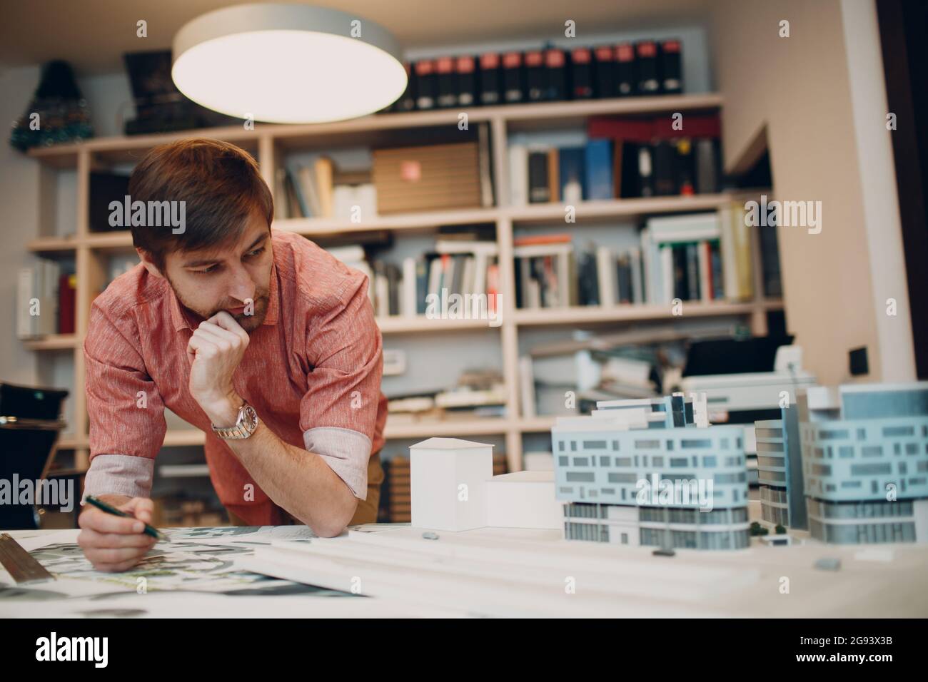 Thoughtful architect with blueprints and layout design project at office. Stock Photo