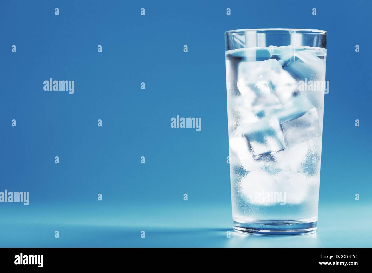 Glass with water and ice cubes on a blue background. Rescue concept on ...