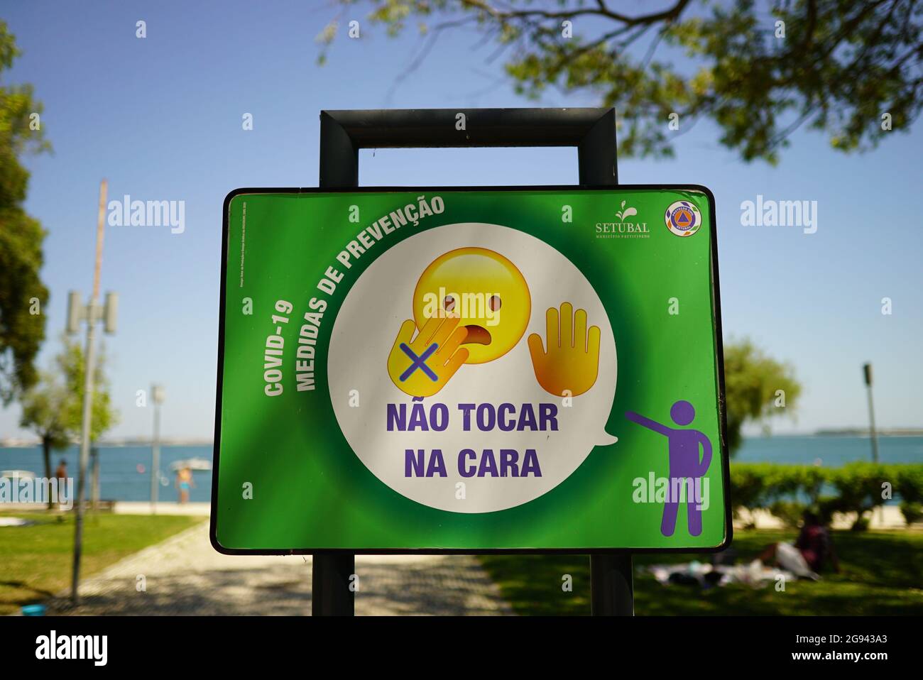 SETUBAL, PORTUGAL - Jul 04, 2021: A Portuguese sign with Covid 19 prevention measures saying "Don't touch your face" Stock Photo