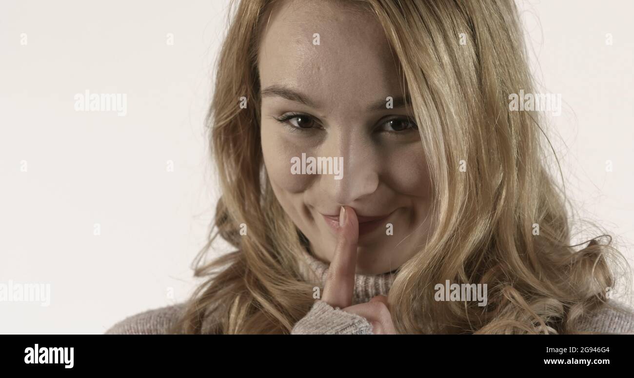 Silent, Young woman showing gesture of silence Stock Photo