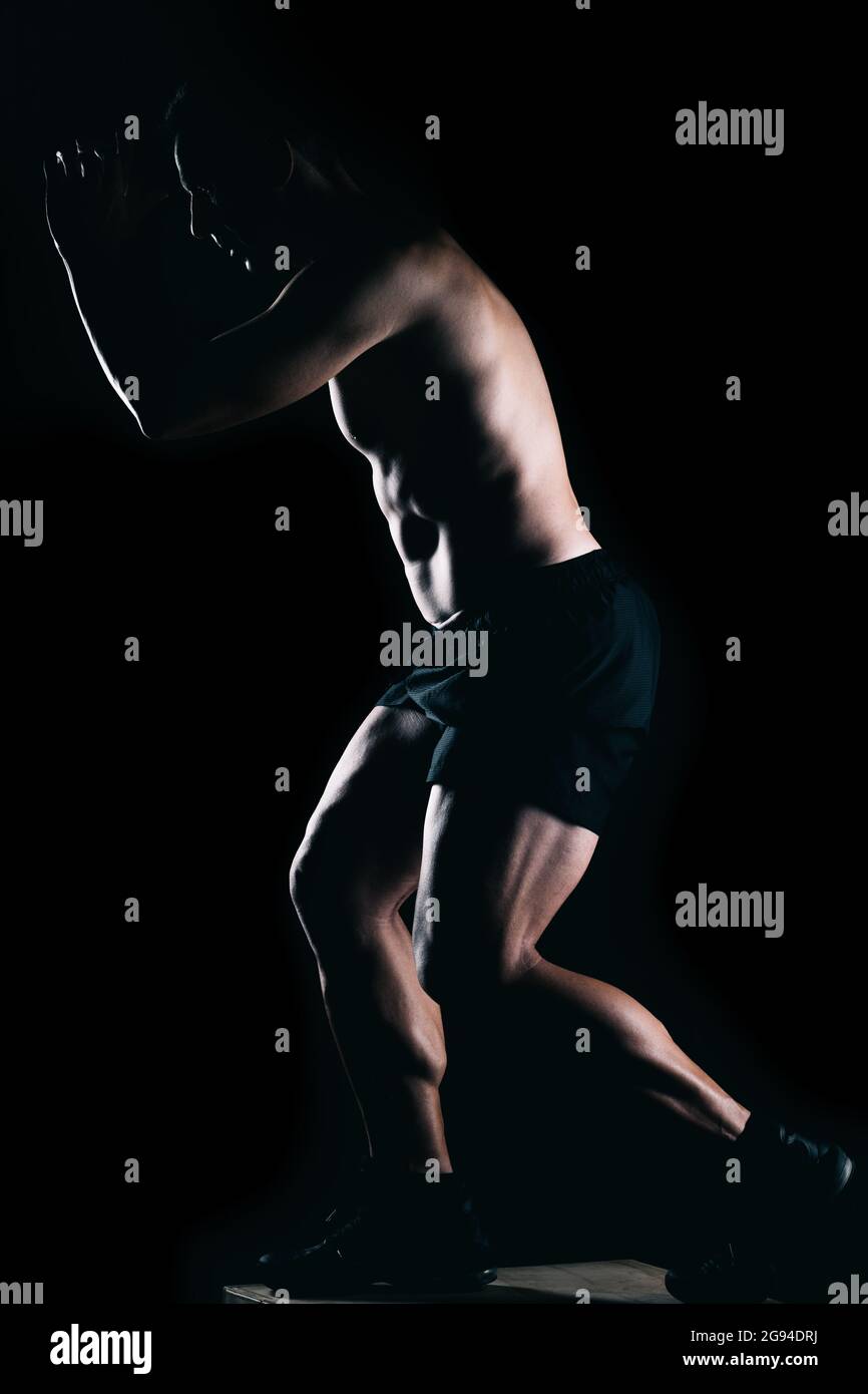 Strong man doing exercises on top of a box. Stock Photo