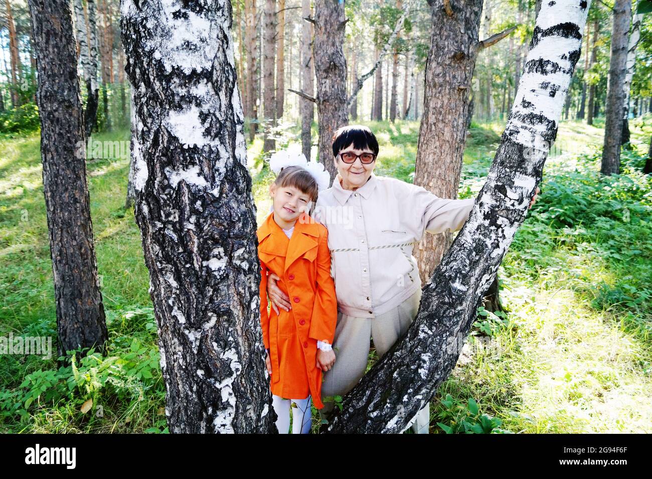 Grandmother with her first-grader granddaughter in the forest Stock Photo