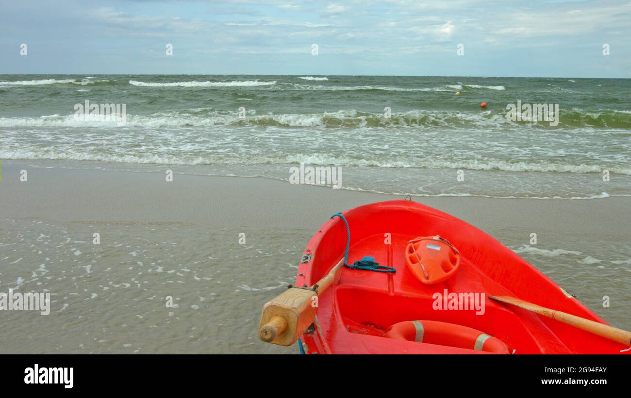Red baywatch boat on beach. Rescue boat for emergency alert. Slowmotion. Stock Photo
