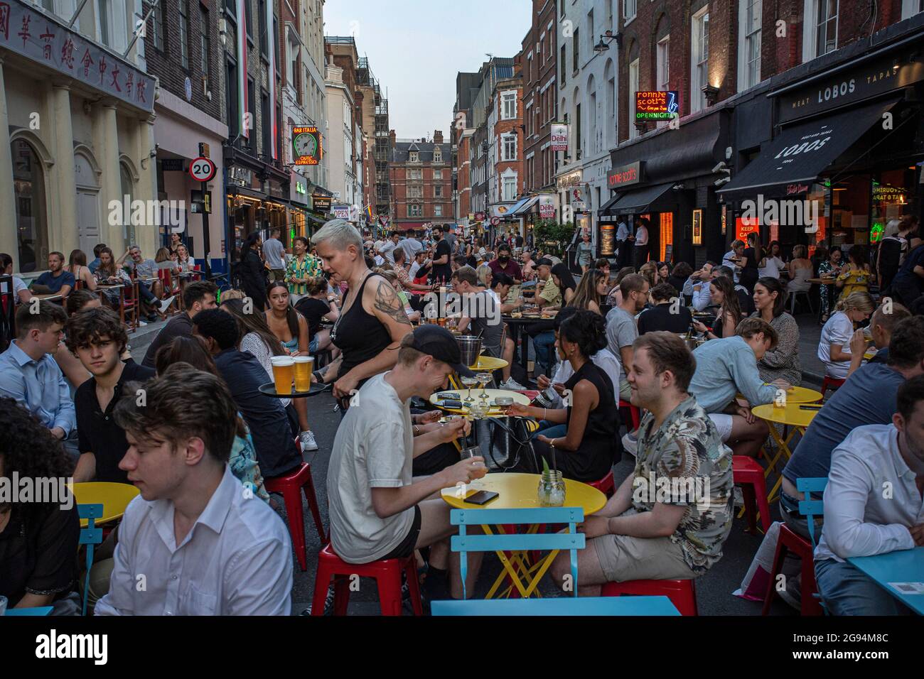 People eating on restaurant tables placed outside Frith Street ,Soho , London , United Kingdom. Stock Photo