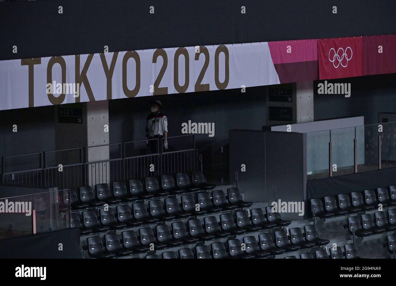 Tokyo, Japan. 24th July, 2021. A staffer stands with empty seats in Musashino Forest Sport Plaza during the badminton competition at Tokyo 2020 Olympics in Tokyo, Japan, July 24, 2021. Credit: Guo Chen/Xinhua/Alamy Live News Stock Photo