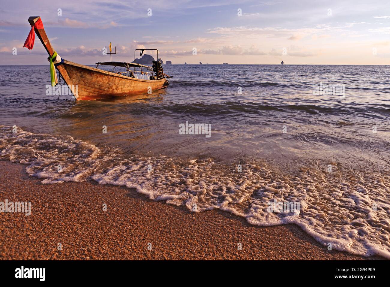 Boat on tropical beach in light of sunset Stock Photo - Alamy