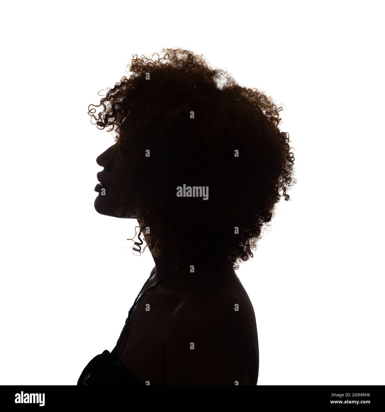 Black profile of an African woman on a white background, shaded silhouette, head and shoulders. Stock Photo