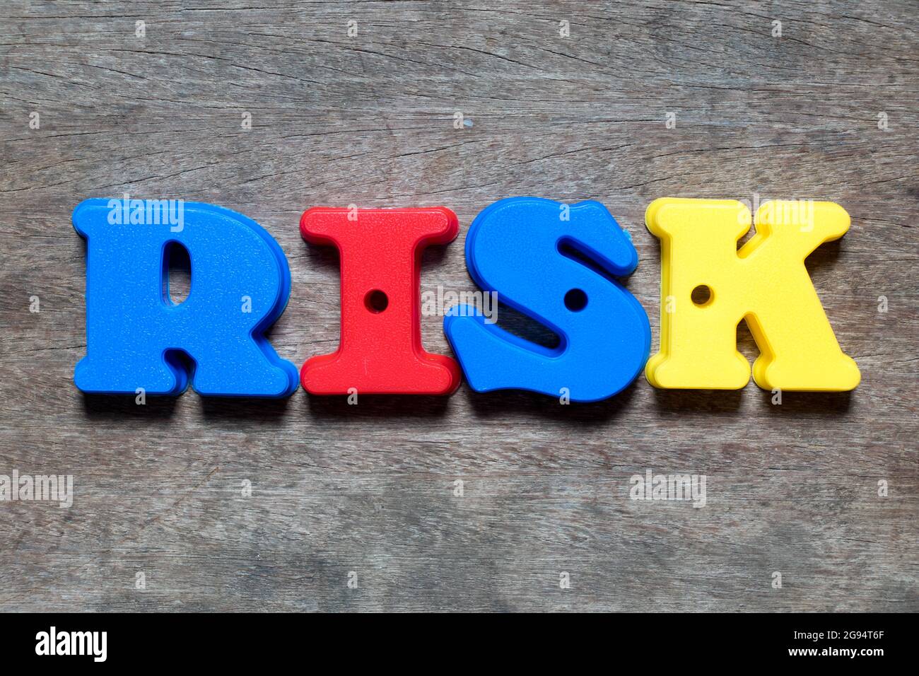 Color alphabet in word risk on wood background Stock Photo - Alamy