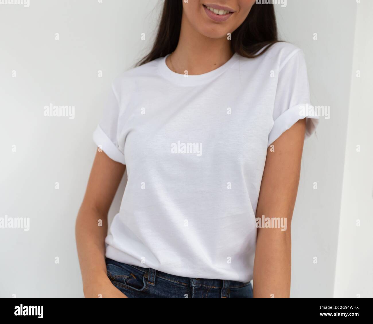 Tshirt mockup, front view of unrecognizable woman wearing white tshirt. Copy space on empty area on her t-shirt for design or inscription. Fashion lifestyle mock up of white tshirt. T-shirt template. Stock Photo