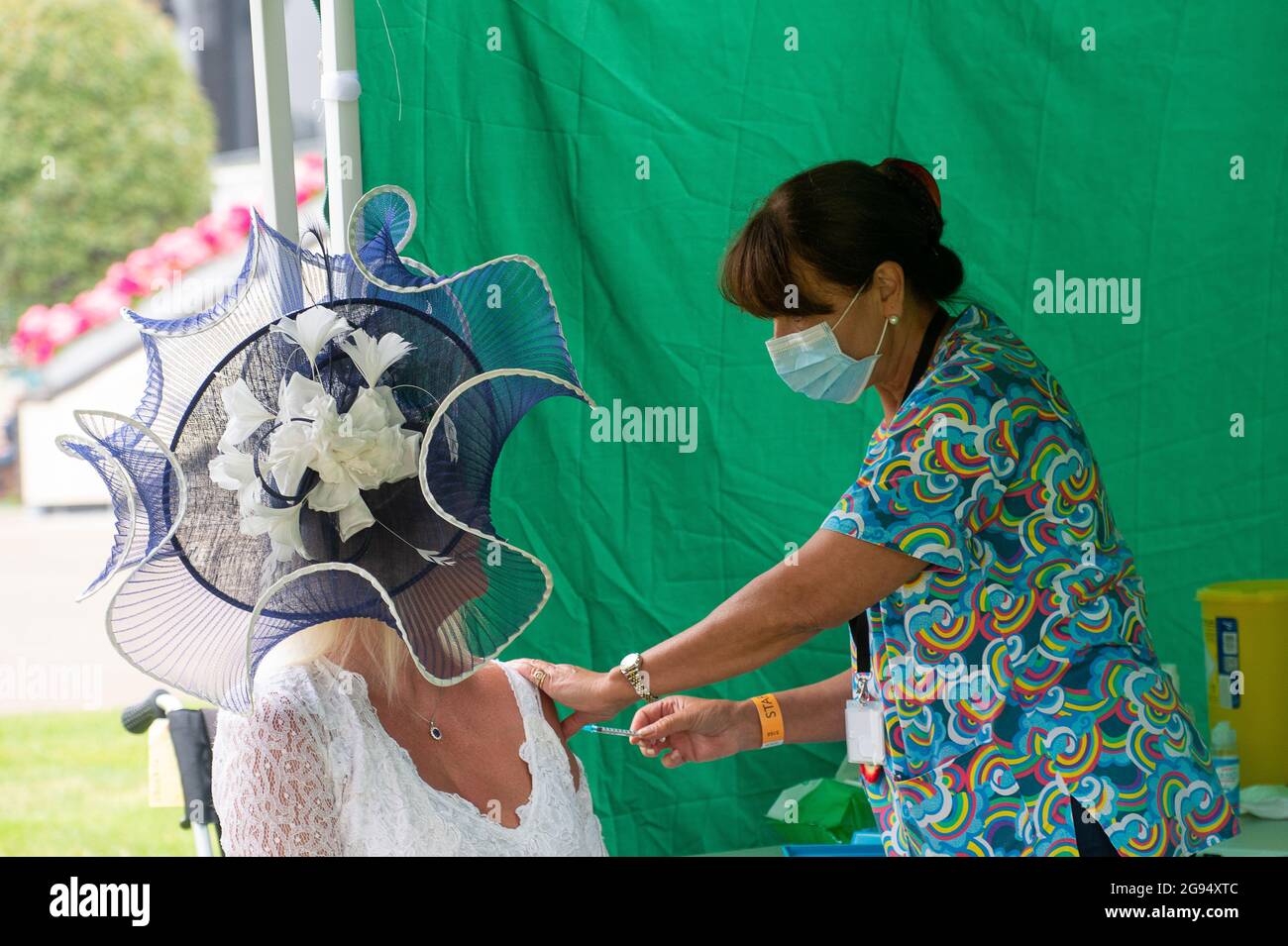 Ascot, Berkshire, UK. 24th July, 2021. Jacqueline Hoole wore a beautiful hat today at Ascot Racecourse and took the opportunity to have her Covid-19 jabs today. Credit: Maureen McLean/Alamy Live News Stock Photo
