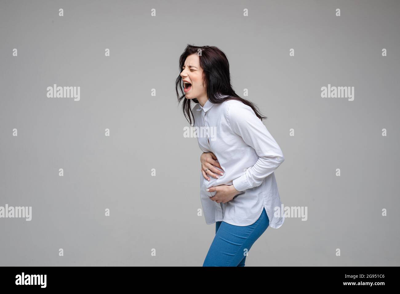 beautiful young pregnant woman screaming beacuse of a strong stomach ache Stock Photo