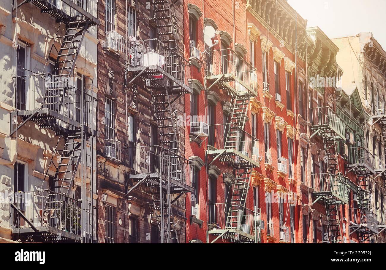 Old buildings with fire escapes in New York City, color toning applied ...