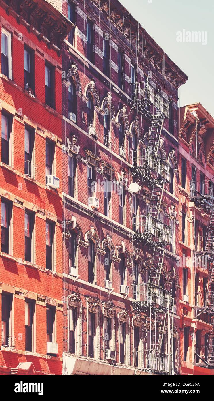 Old buildings with fire escapes in New York City, color toning applied ...