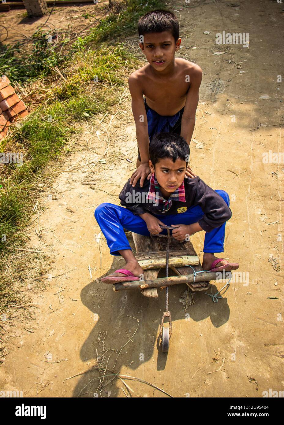 Boys are playing in a traditional toy car on the village street. This image has been captured on January-13-2018 by me, from Dhamrai, Bangladesh, Sout Stock Photo