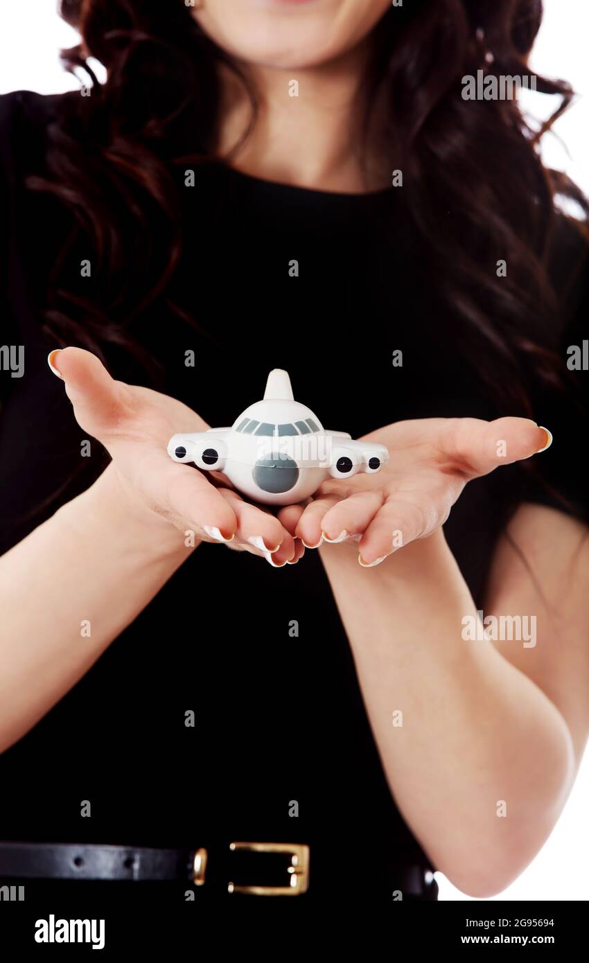 Woman holding toy plane, flying by plane conceptoin. Stock Photo