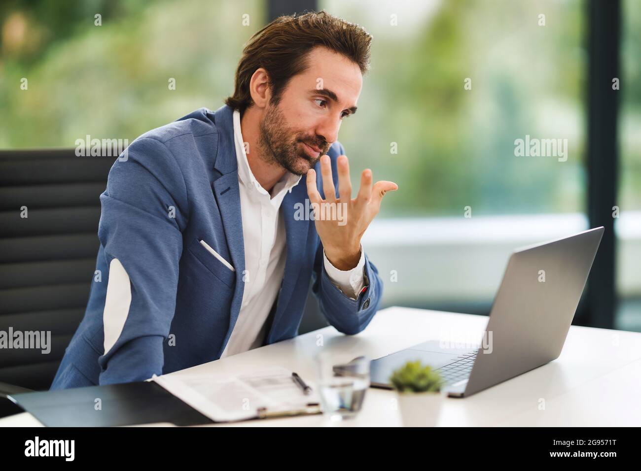 A man sitting at a table using a laptop Stock Photo