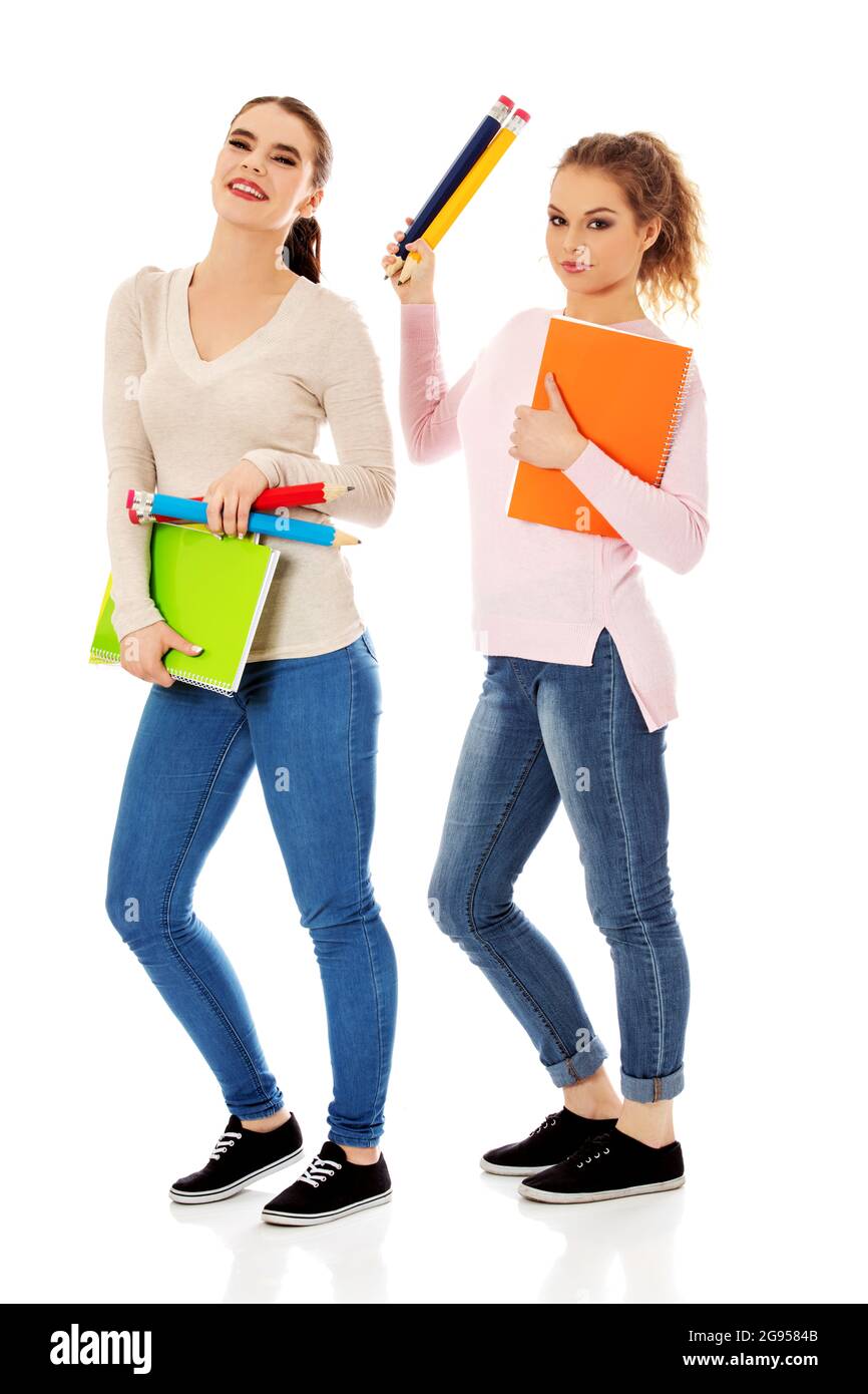Portrait of a cute young student girls holding colorful notebooks, isolated on white background Stock Photo