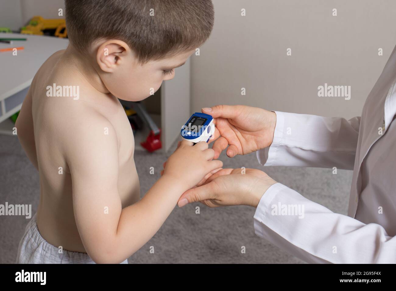 The pediatrician measures the child's blood oxygen level with a pulse