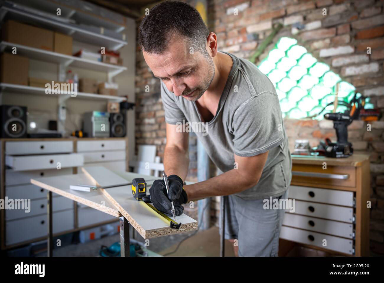 Carpenter Using Ruler Close up of focused carpenter holding ruler and pencil while making ...