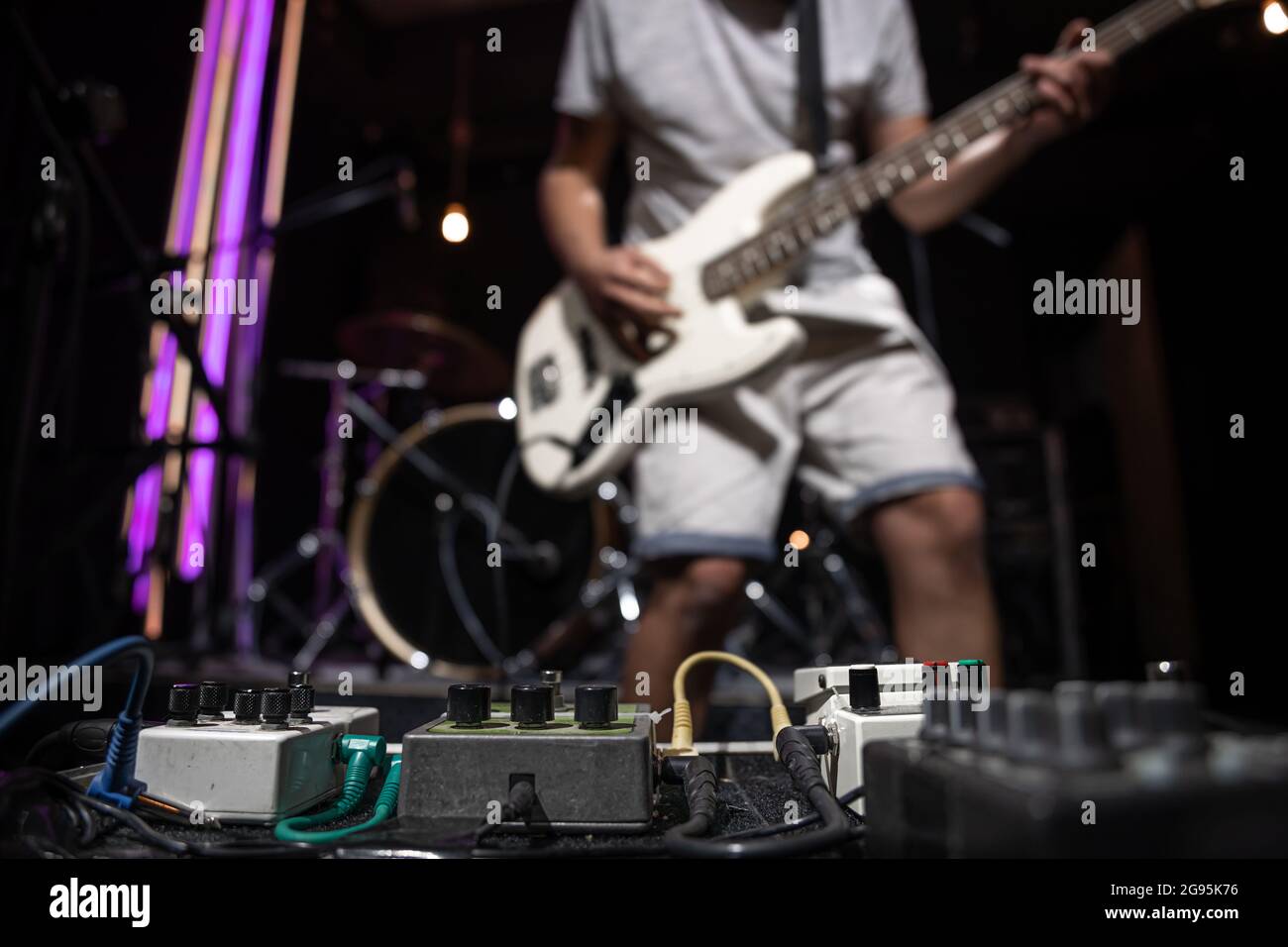 Bass guitar player on a stage with set of distortion effect pedals