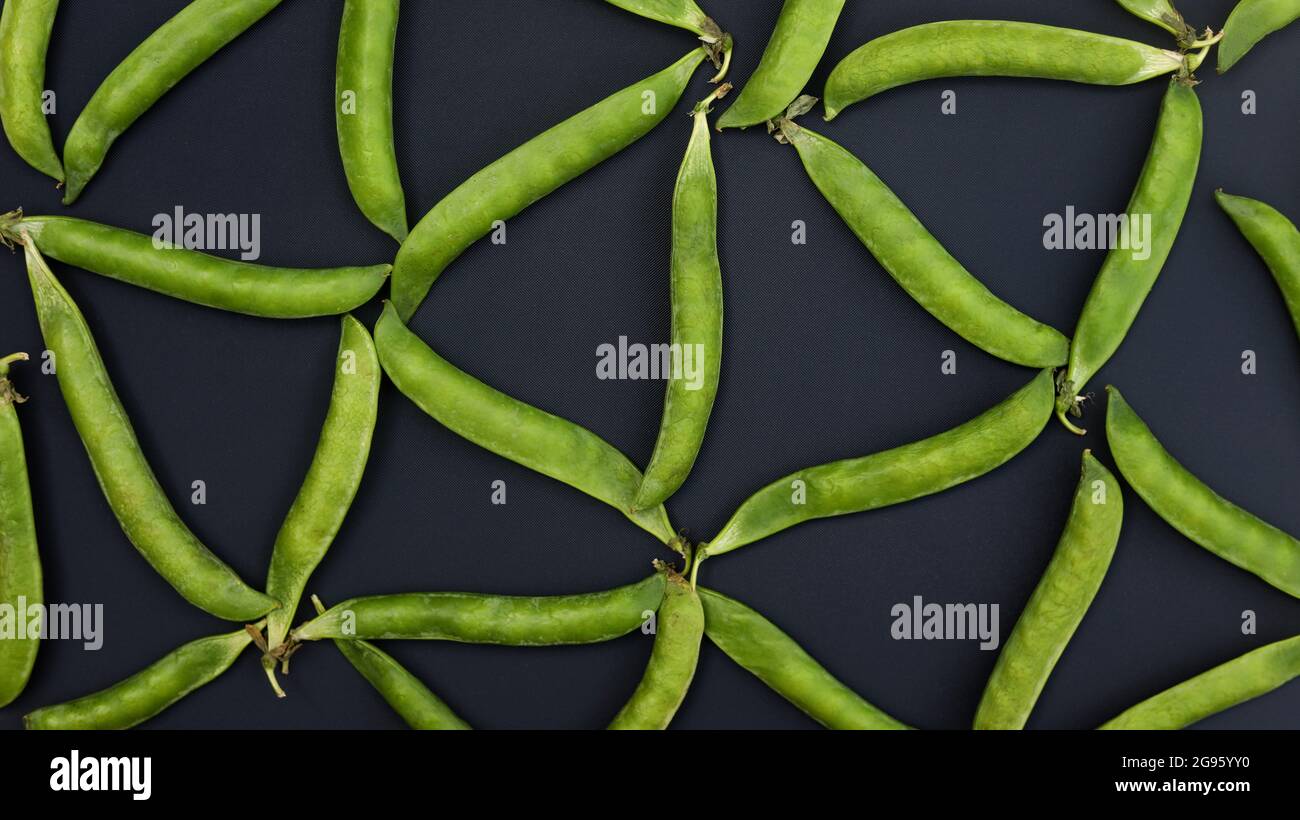 Triangle pattern from green peas on a dark background Stock Photo