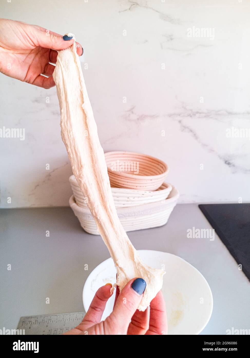 The baker checks a piece of dough for elasticity before kneading Stock Photo Alamy