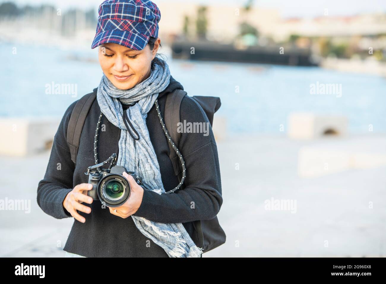 Woman checking settings on her DSLR before taking a picture Stock Photo