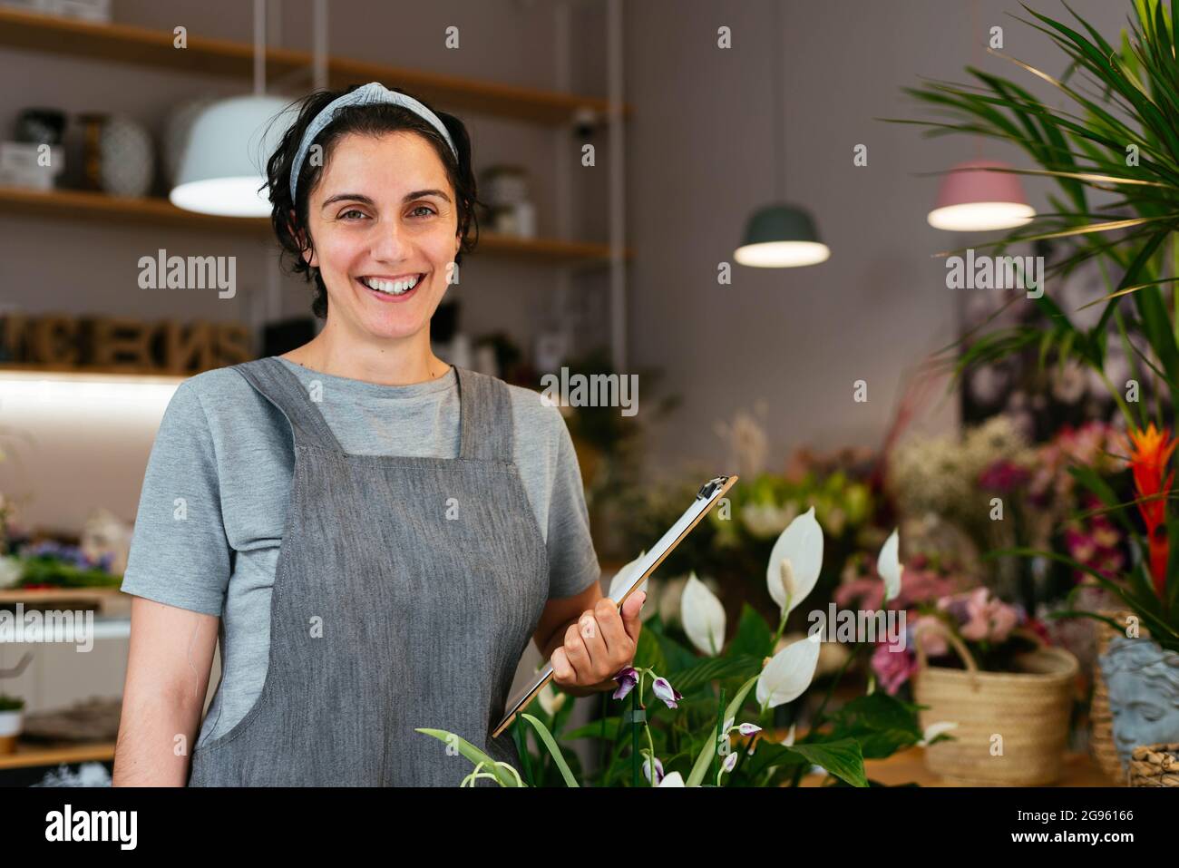 Portrait of a young female florist working in her shop Stock Photo