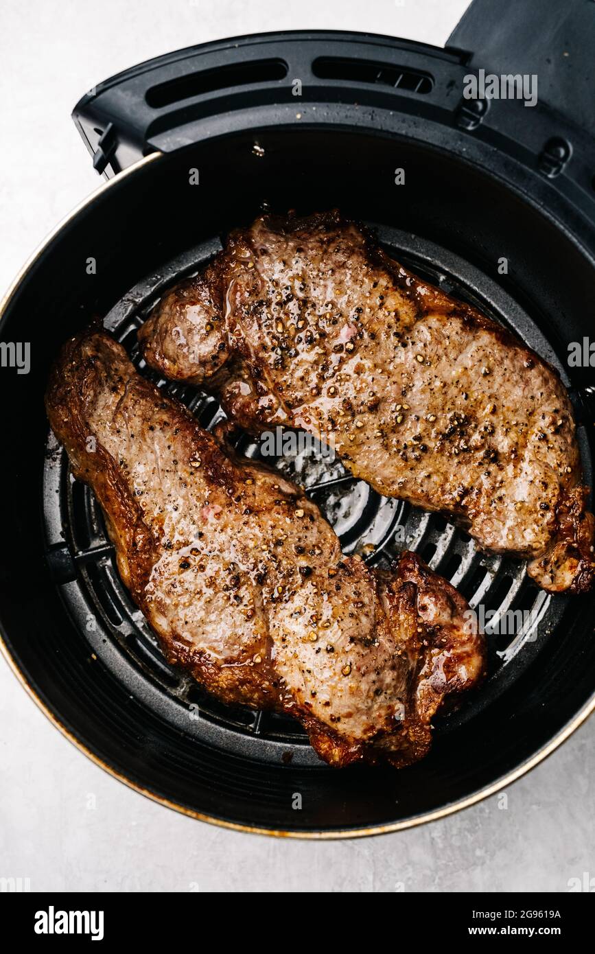 Cooking steaks in an air fryer Stock Photo Alamy