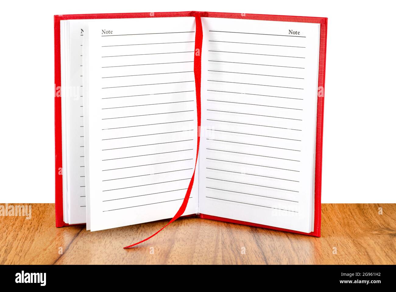 Open red lined notebook standing on a wooden table, isolated on a white background. Stock Photo