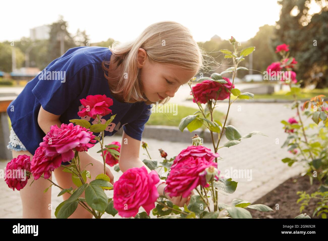 Young girl smelling flowers in the city Stock Photo - Alamy