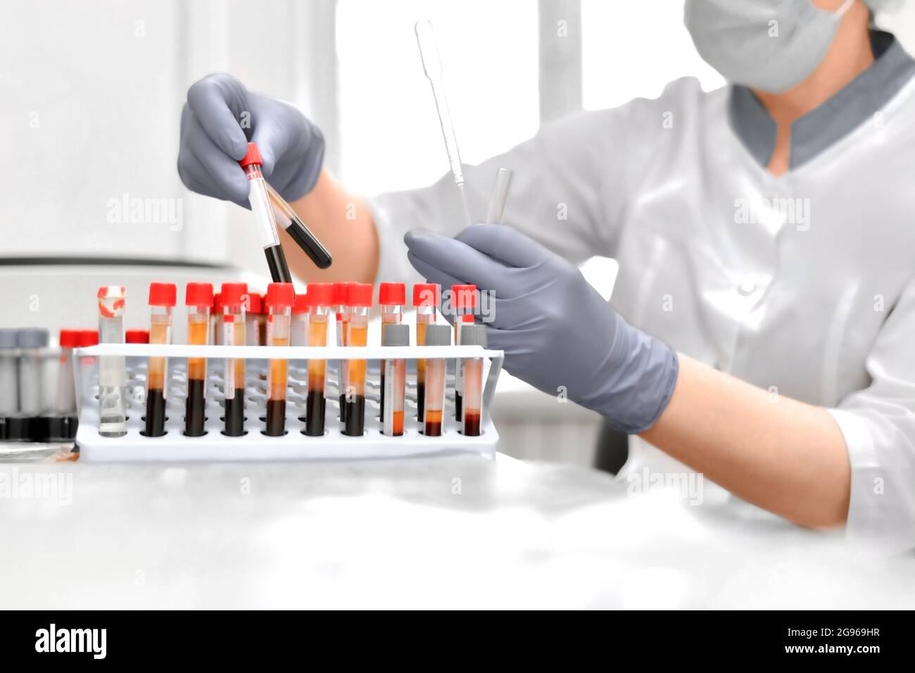 The work of the laboratory assistant with blood tests in test tubes. Hand gestures in protective gloves. Stock Photo