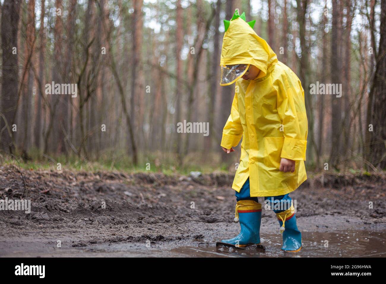 Child in a yellow raincoat walking in a 
