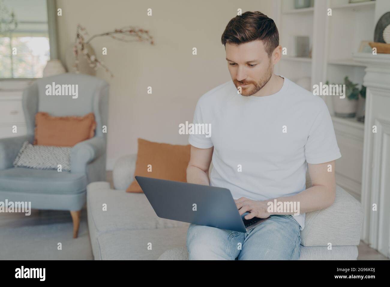Serious young man using laptop computer for remote work from home Stock Photo