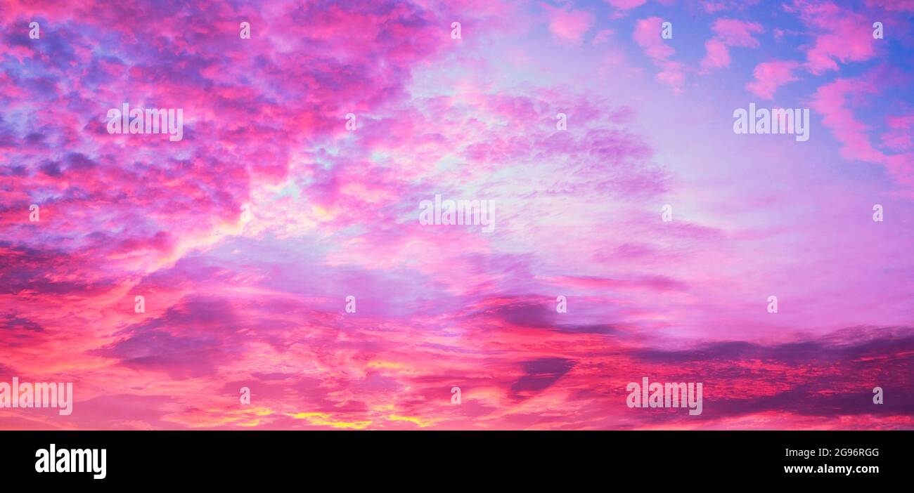 Dramatic purple sky with fluffy clouds Stock Photo