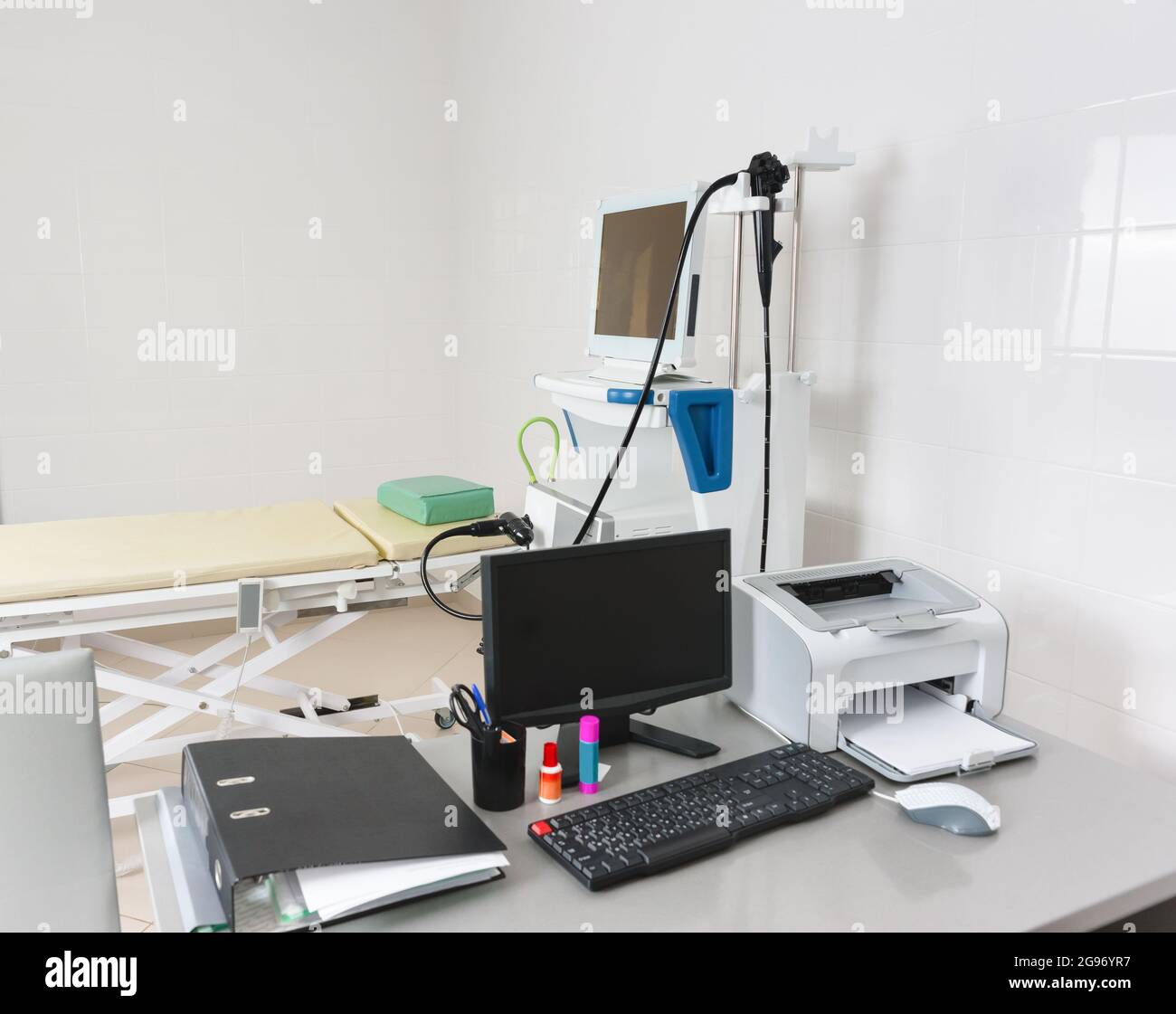 The doctors desk with a monitor and a computer in the endoscopy room. In the background there is a stand with a video esophagogastroduodenoscope Stock Photo