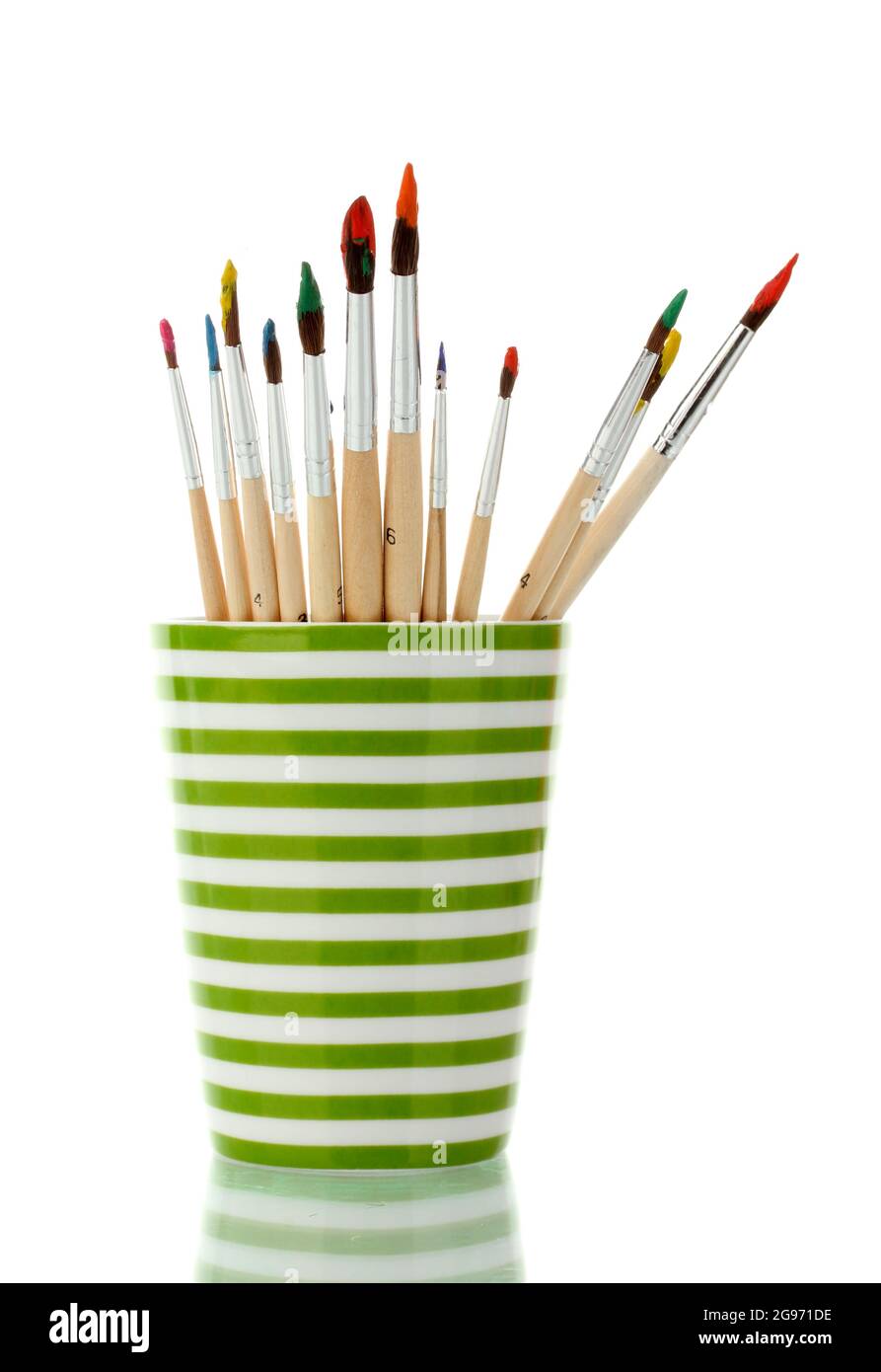 Paint brushes with gouache in cup isolated on white - Stock Photo