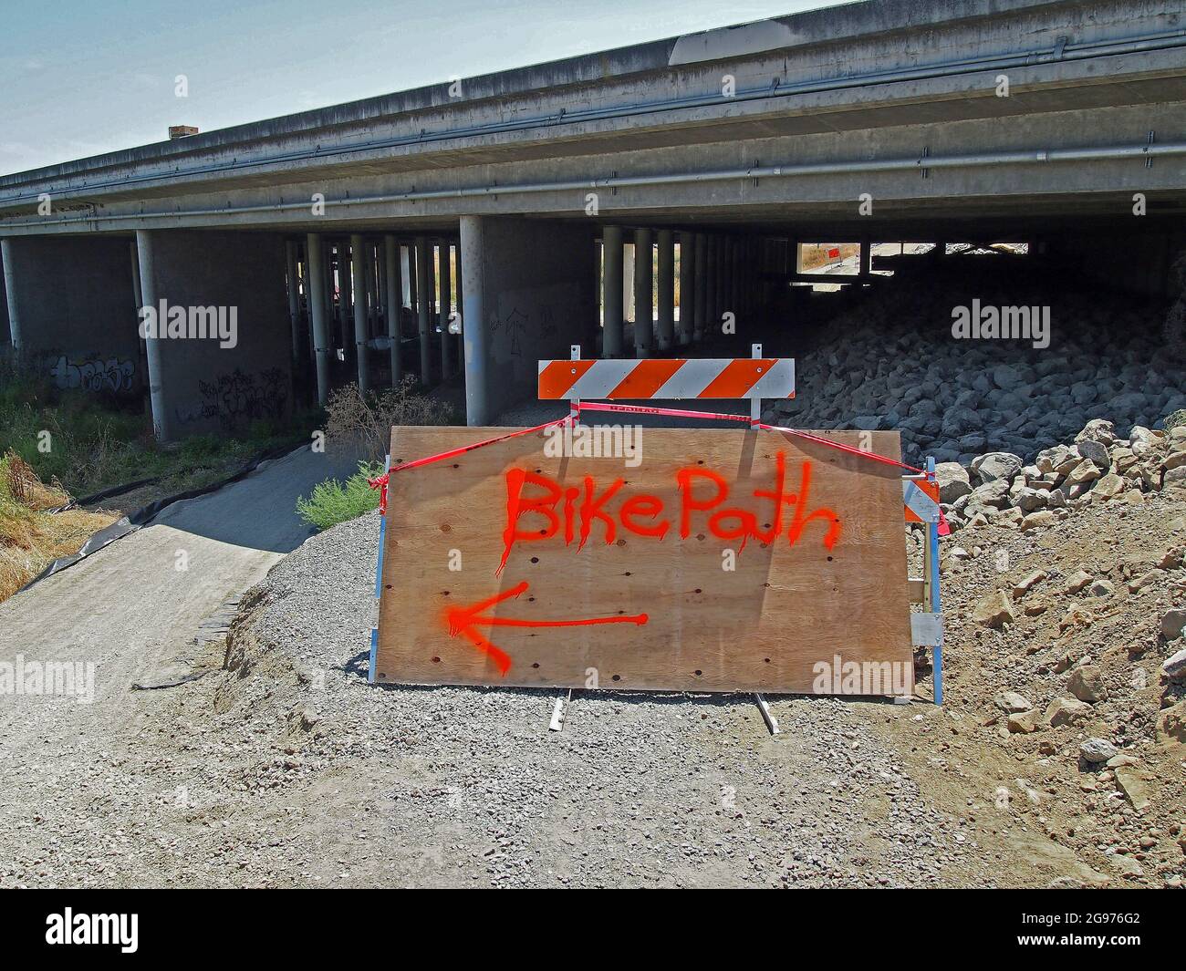 Bike Path detour arrow sign from Alameda Creek trail to Alameda creek under the I-880 freeway overpass due to overpass re-enforcement, infrastructure work. Union City, California Stock Photo