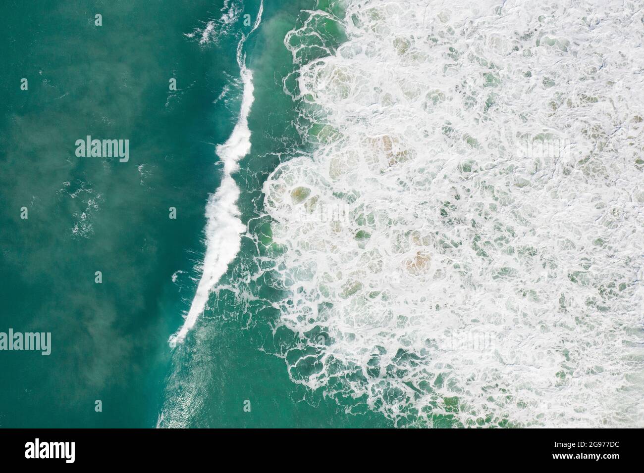 Beautiful aerial view of blue pristine water with surfers and gentle waves Stock Photo