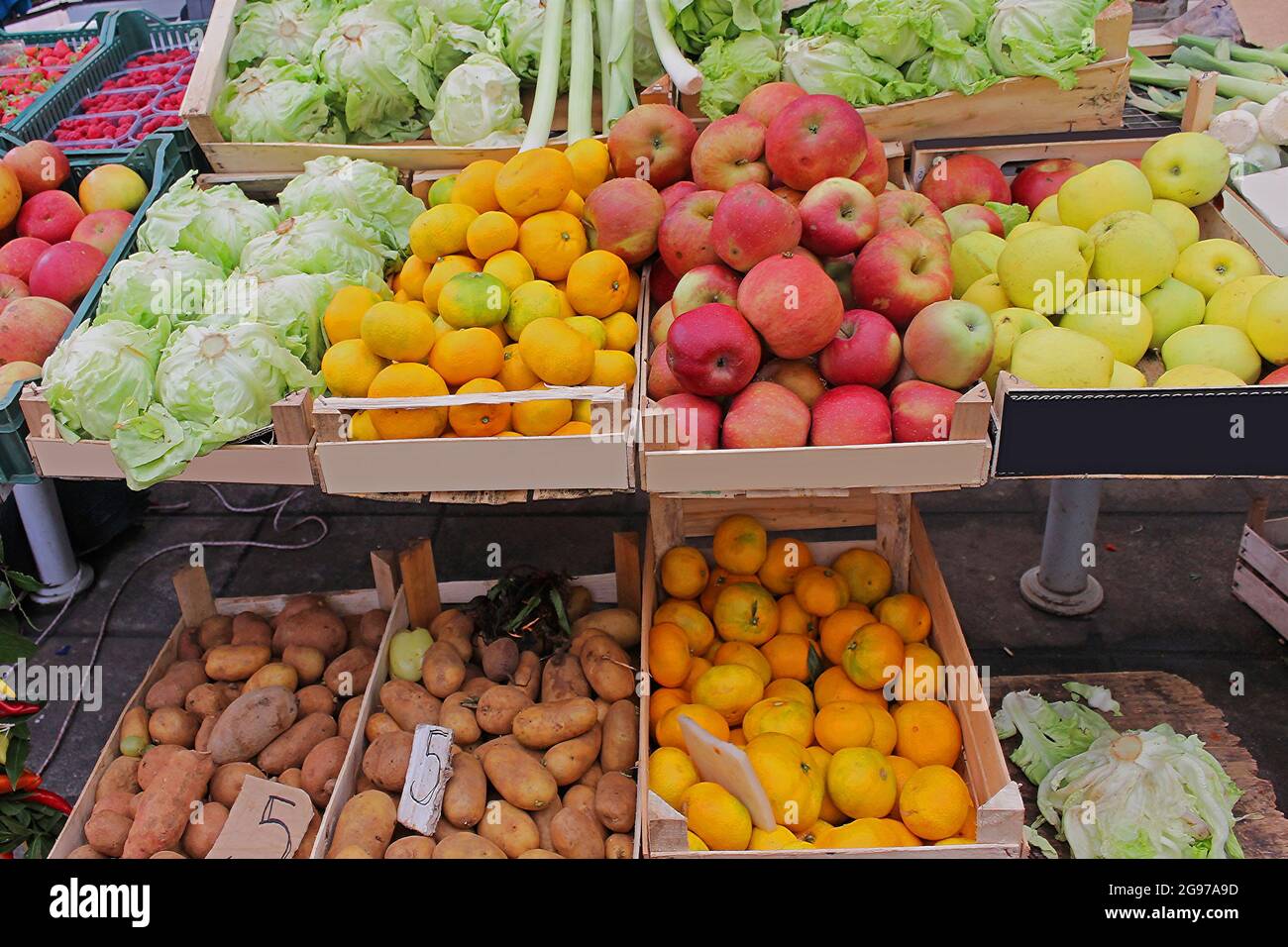 Organic fruits and vegetables in wooden crates sold on market stall ...