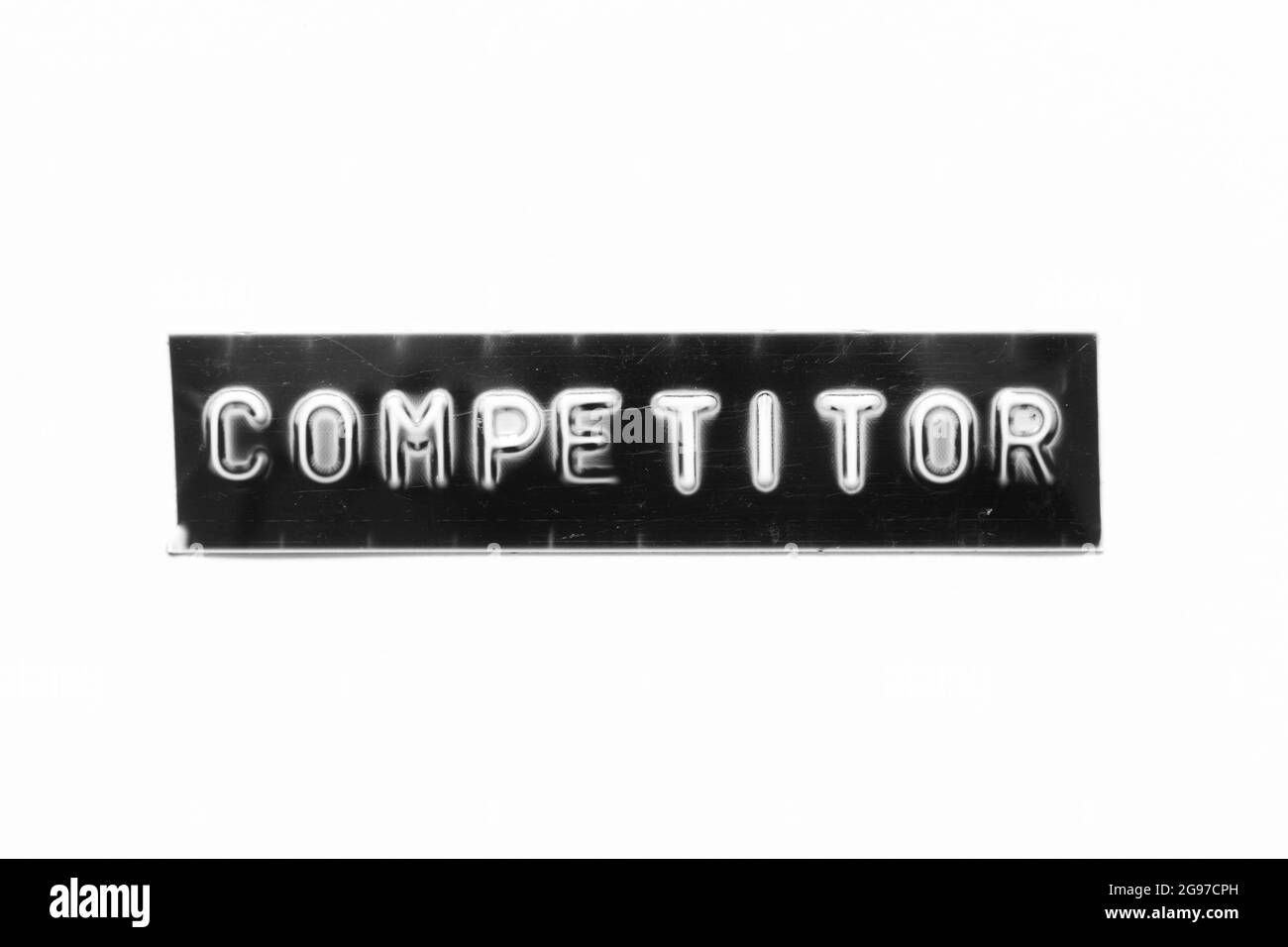 Embossed letter with word competitor in black banner on white paper ...