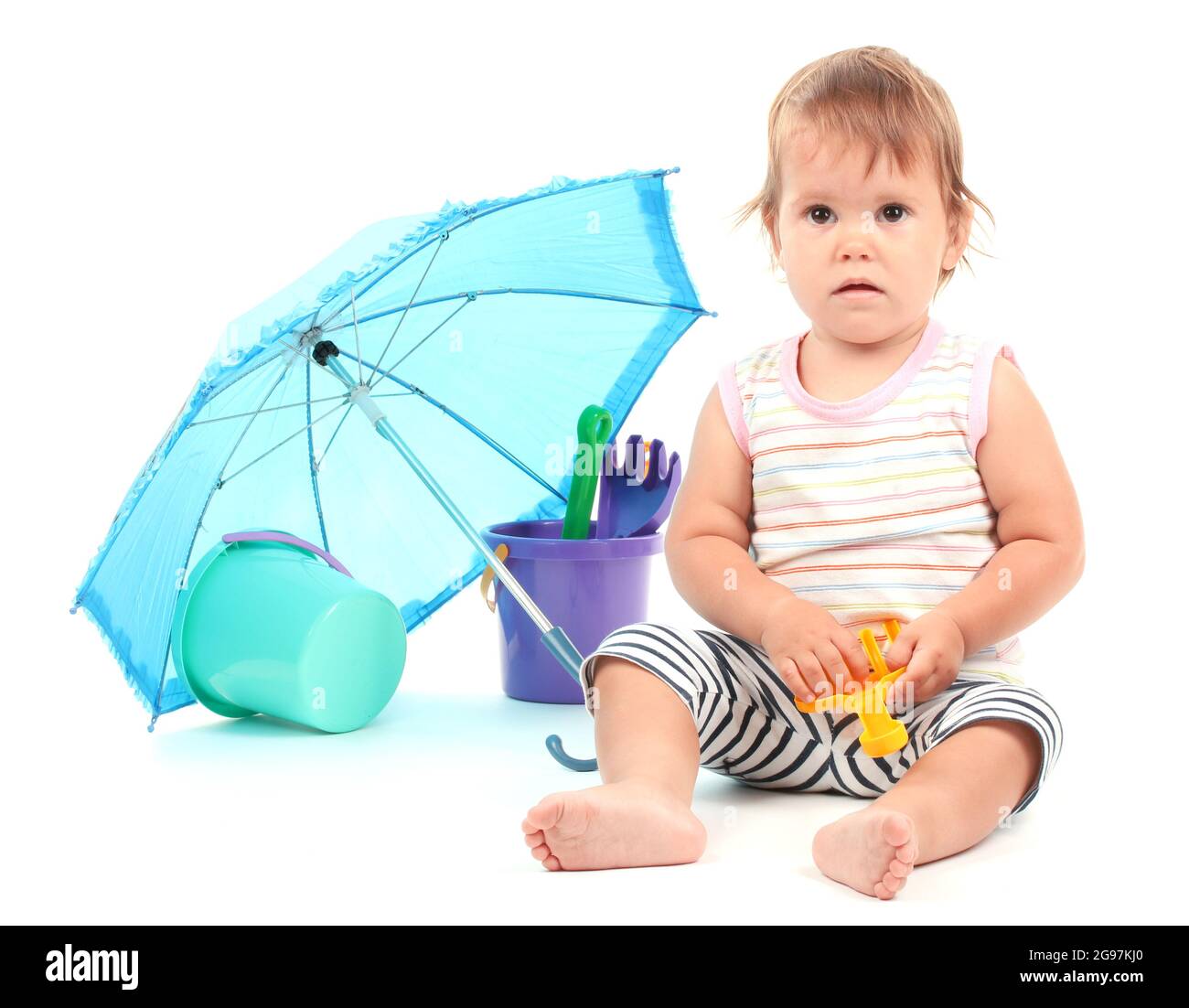 Cute baby with bucket and spade near umbrella isolated on white Stock