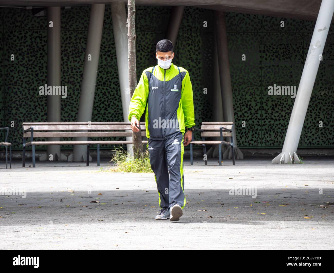 Medellin, Colombia - July 21 2021: Young Latin Men in a Fluorescent Outfit Walks in a Public Park and Stares Stock Photo
