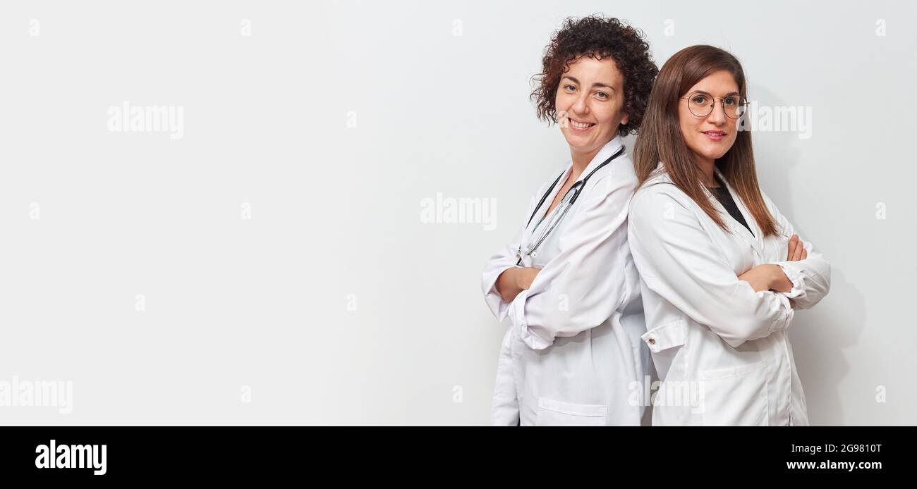 Portrait of two female doctors back to back looking at camera Stock Photo